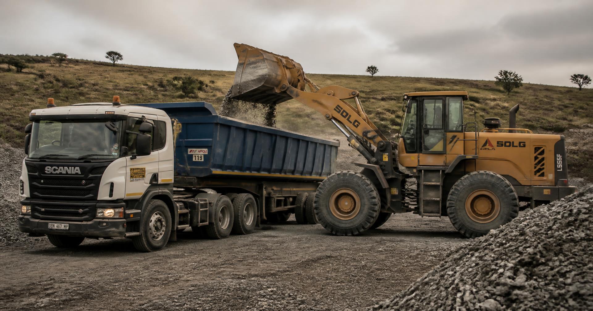 Front-end loader filling a tipper truck with crushed stone at the quarry